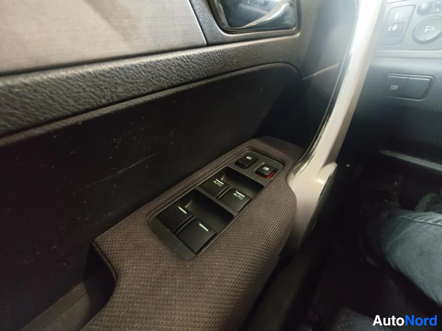 Yksityiskohta: Oven sisäpuolen ikkunankytkimet, kaksi AUTO-merkittyä nappia