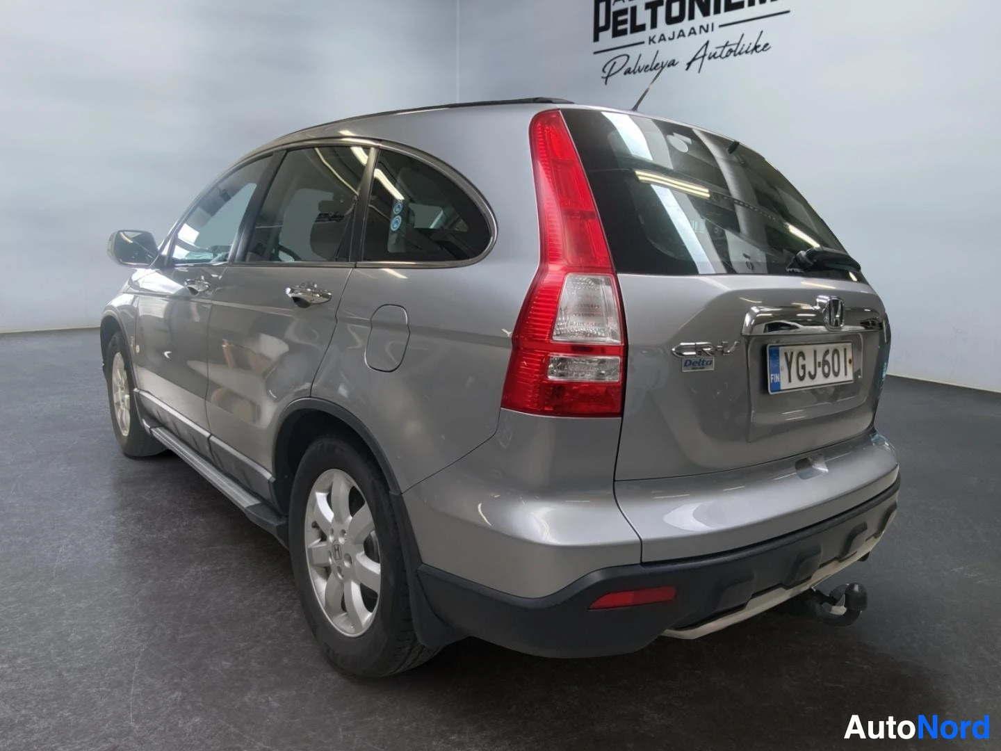 Takaviisto: Hopeanharmaa Honda CR-V kolmasosalla takaa, takavalot, rekisterikilpi ja CRV-merkintä näkyvissä.
