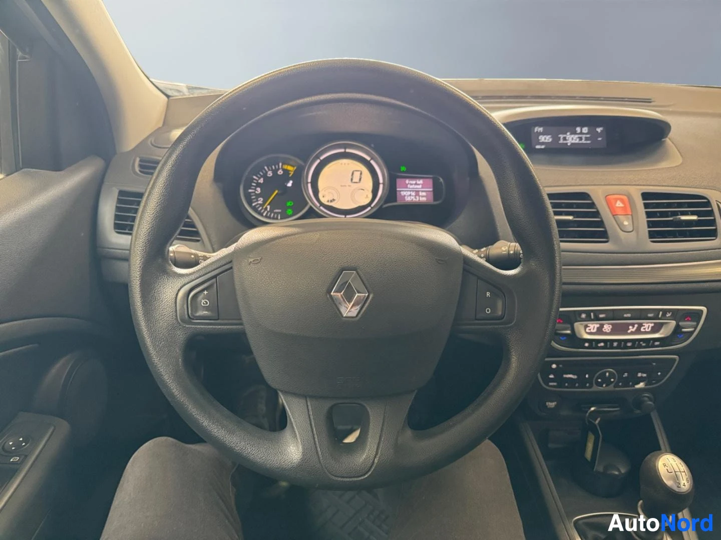 Edestä: Ohjaamo etukuvasta: Renault-ohjauspyörä, analogiset mittarit, manuaalivaihtoaliveksi ja radio-näyttö kojelaudassa.