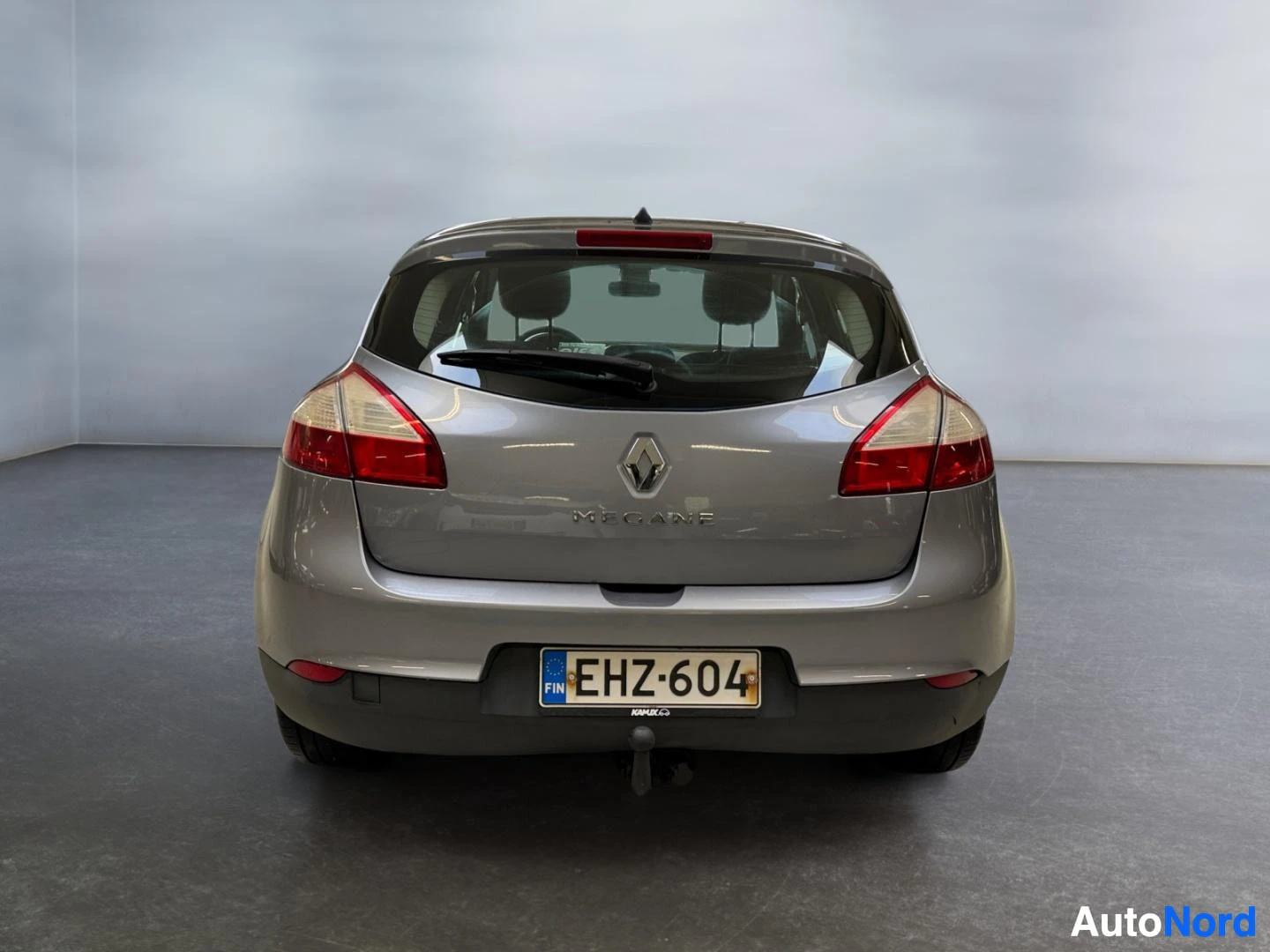 Takaa: Hopeanharmaa Renault Megane suoraan takaa kuvattuna, rekisterikilpi ja rekvaljaat näkyvissä.