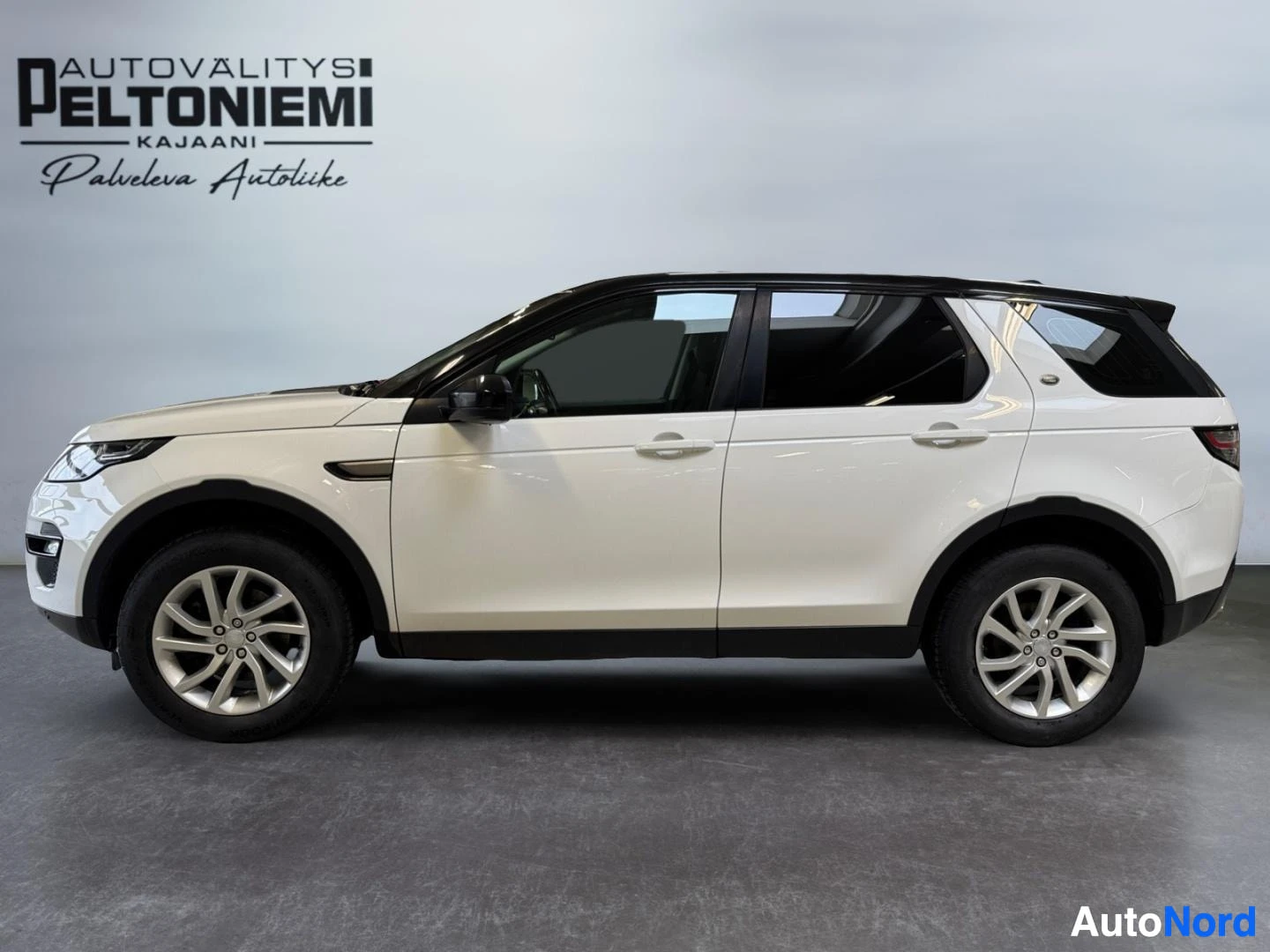Sivulta: Land Rover Discovery Sport, sivukuva valkoisesta autosta, jossa musta katto.