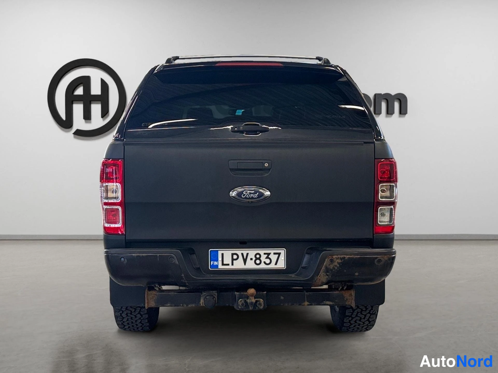 Takaa: Mustan Ford Ranger -novakuljettimen suora takakuva, rekisterikilpi ja Ford-merkki takaovessa.