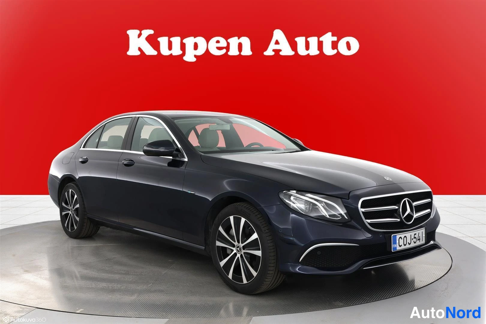 Etuviisto, nokka oikealle: Mercedes-Benz E-sedan tummansinisellä korilla etuviistosta oikealta, rekisteritunnus