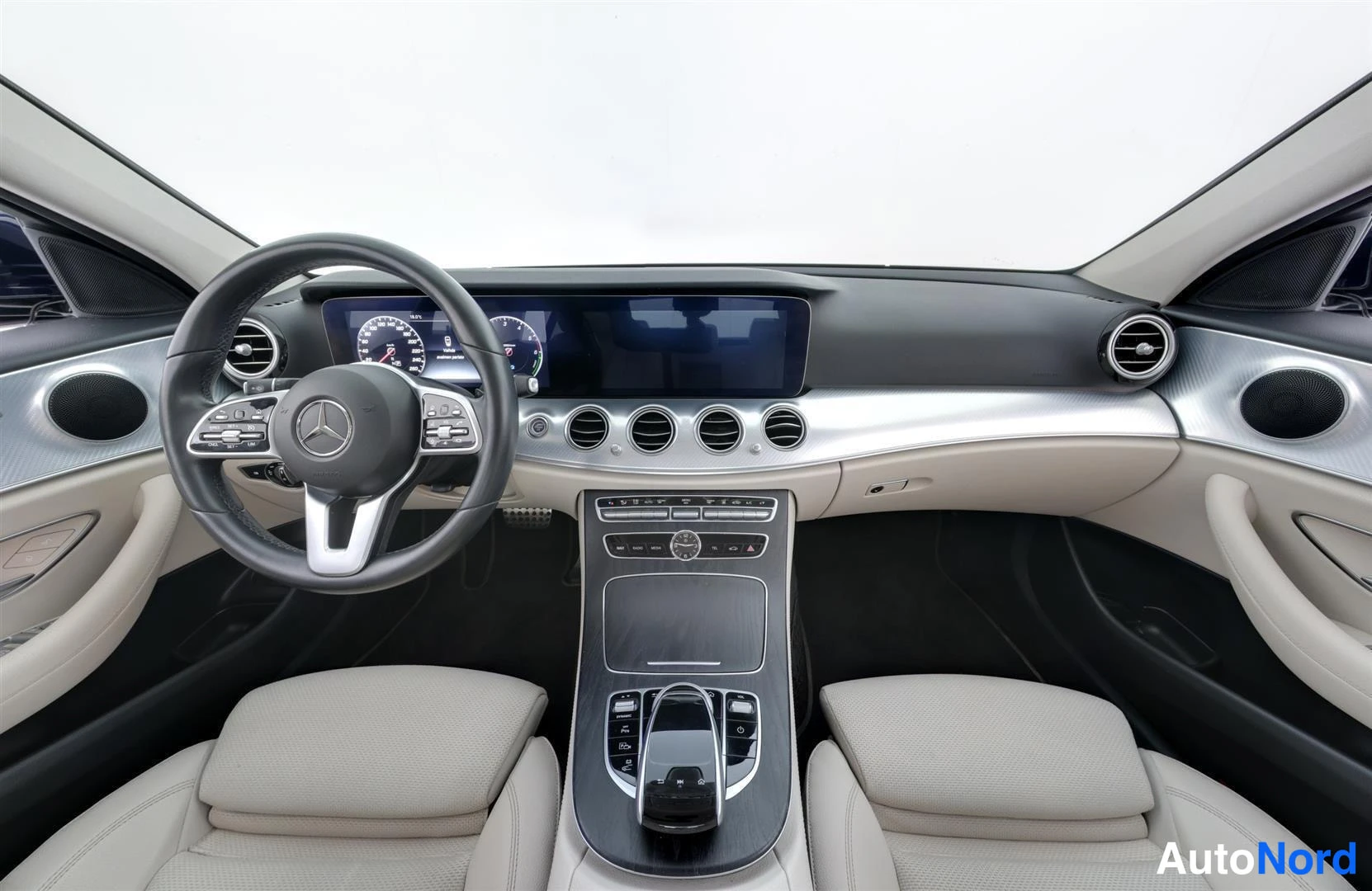 Ohjaamo: Mercedes-Benzin kojelauta ja etuistuimet, vaalea sisusta, digitaalinen mittaristo ja keskinäyttö.