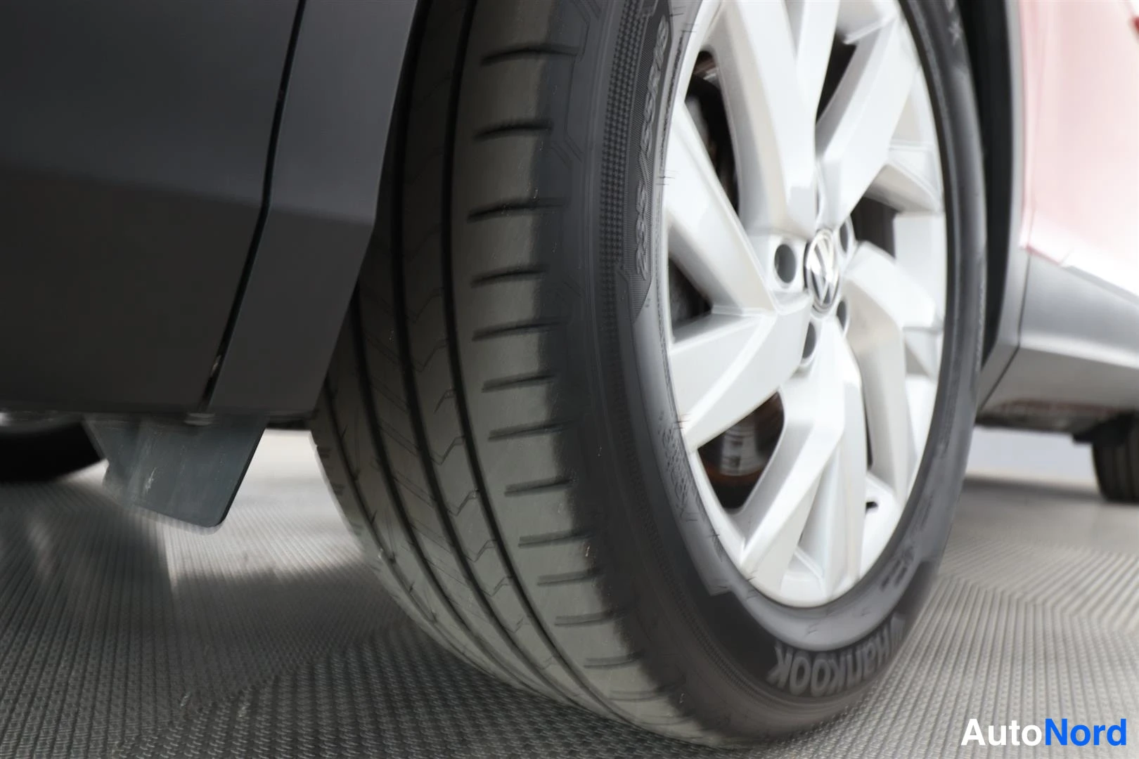 Yksityiskohta: Lähikuva auton etupyörästä ja hopeasta kevytmetallivanteesta, Hankook-rengas näkyvissä.