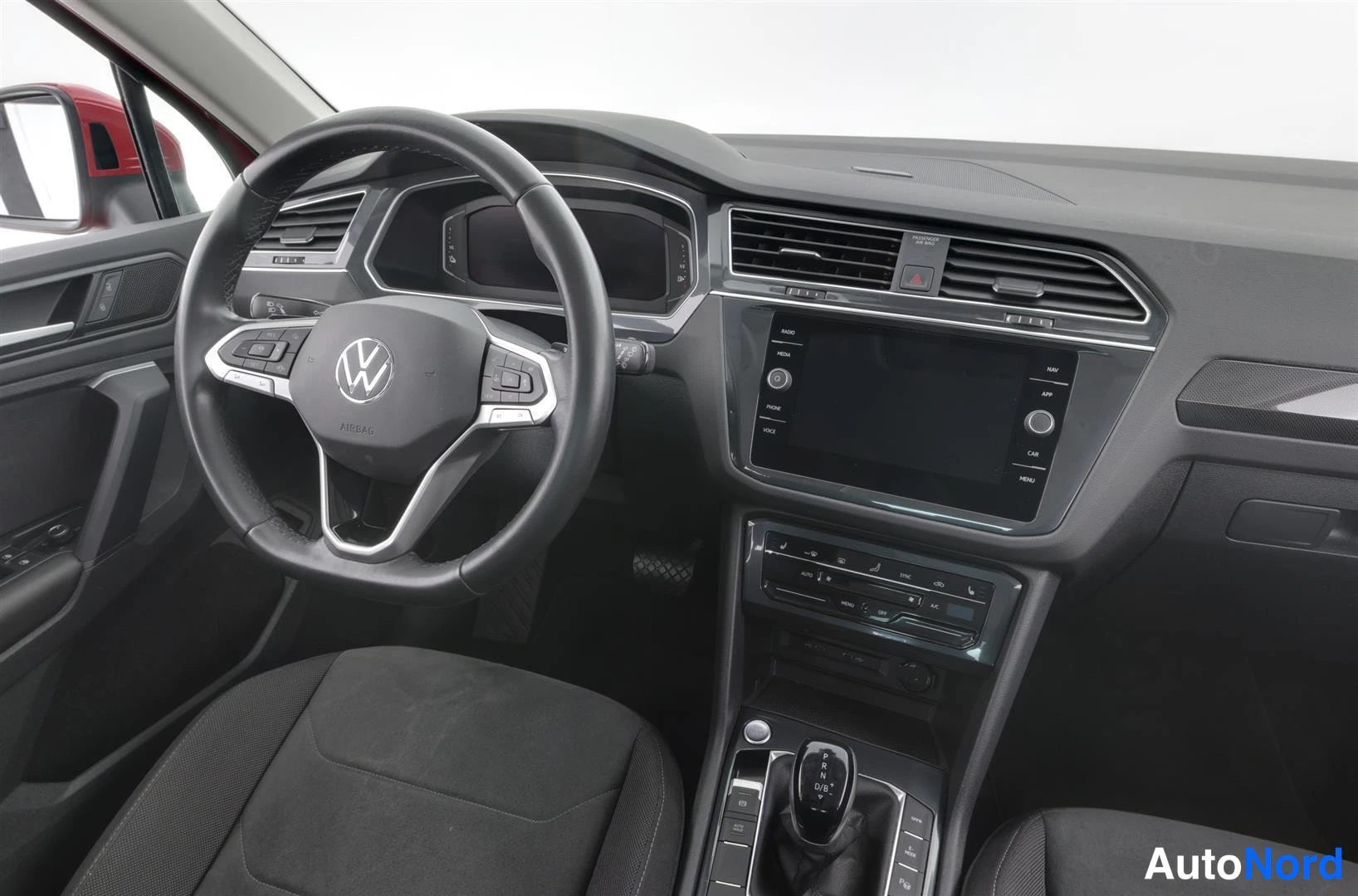 Muu: Auton ohjaamo kuvattuna matkustajan puolelta: Volkswagen-merkkinen ohjauspyörä, mittaristö, keskikonsolin kosketusnäyttö, ilmastointipaneeli ja automaattivaihte