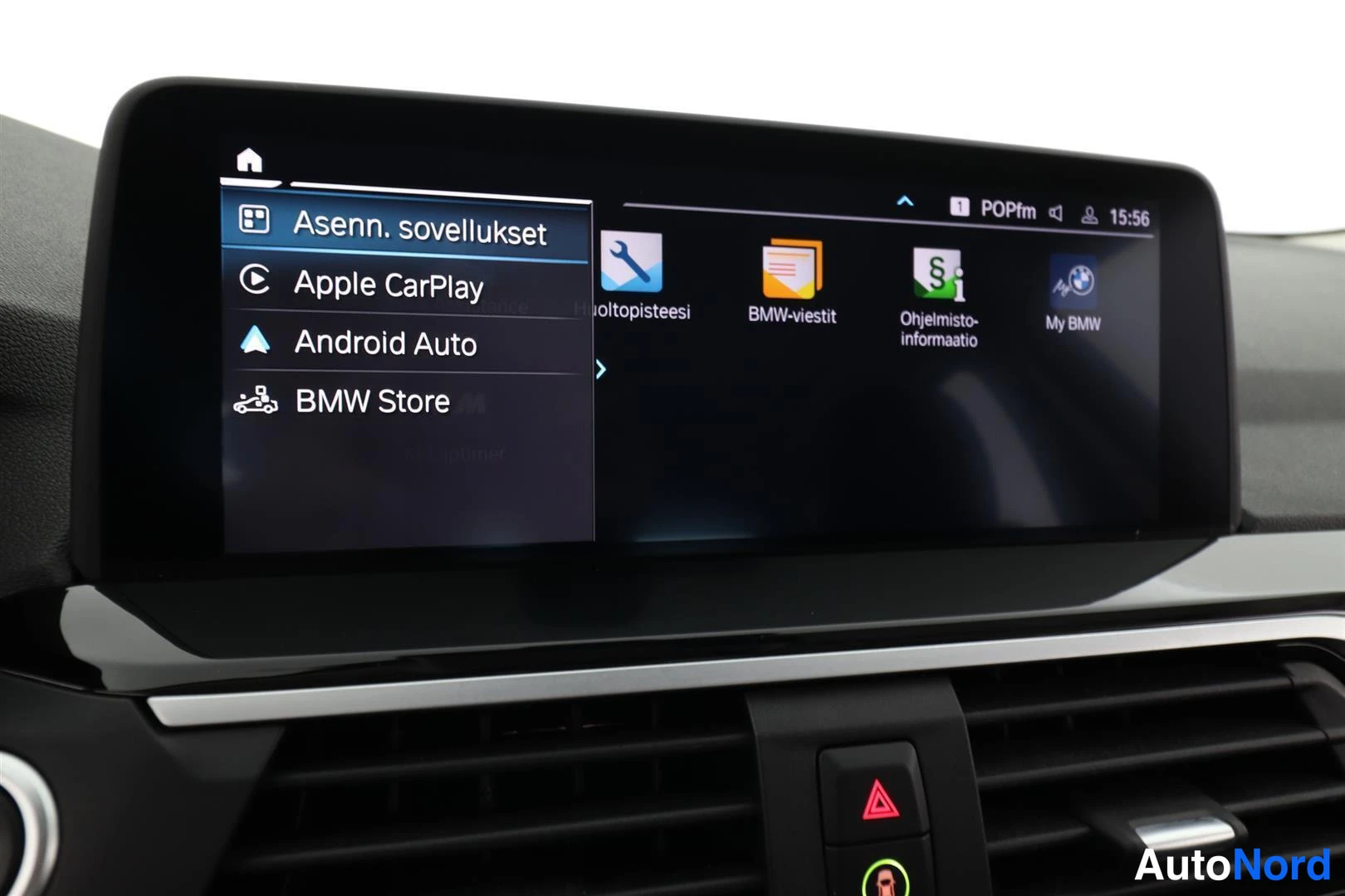 Ohjaamo: Keskuskonsolin näyttö avattuna sovellusvalikkoon, jossa vaihtoehdot Apple CarPlay, Android Auto ja BMW Store.
