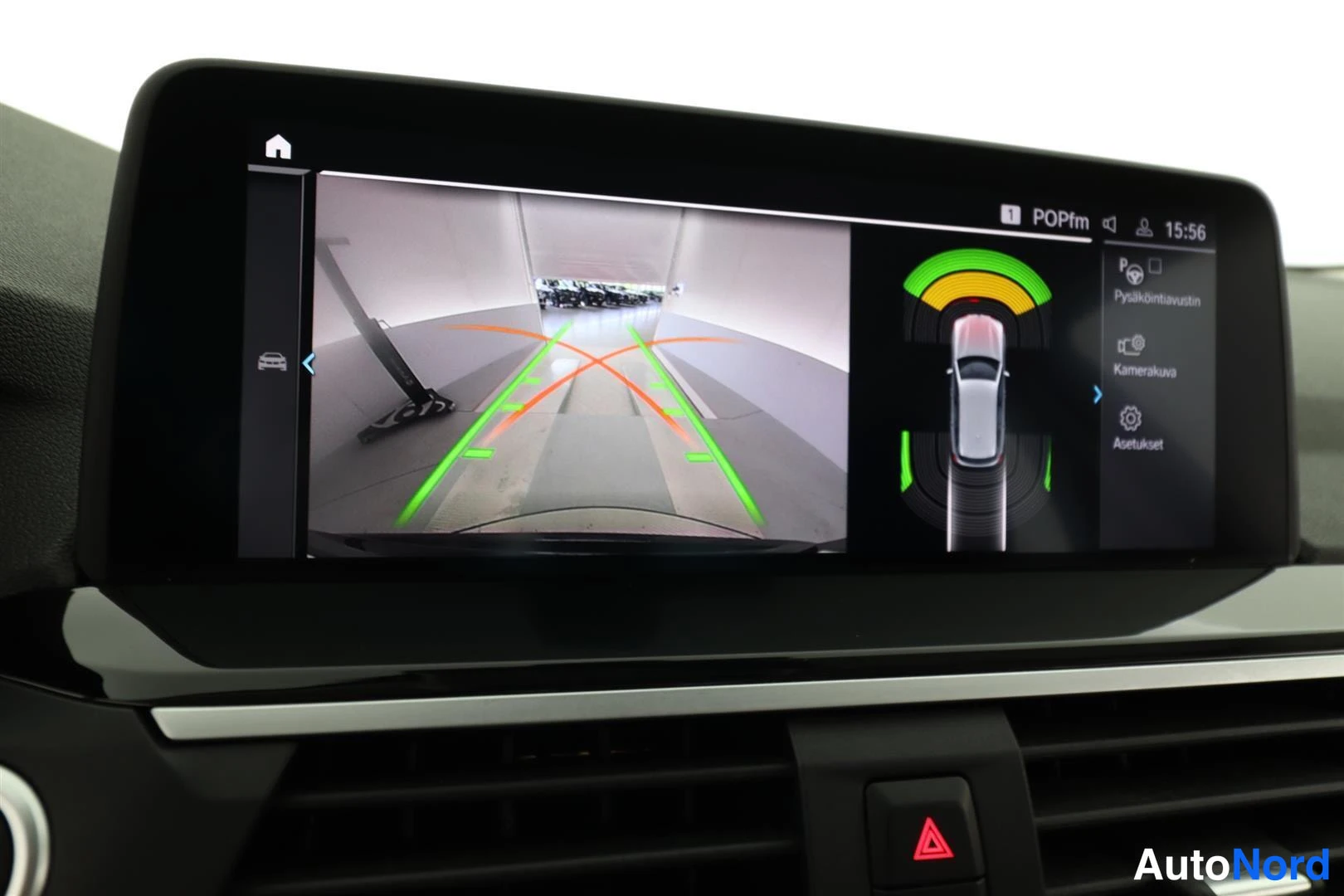 Muu: Infotainment-näyttö näyttää takakameran kuvan ohjausviivoineen ja parkkitutkan kaavioineen.