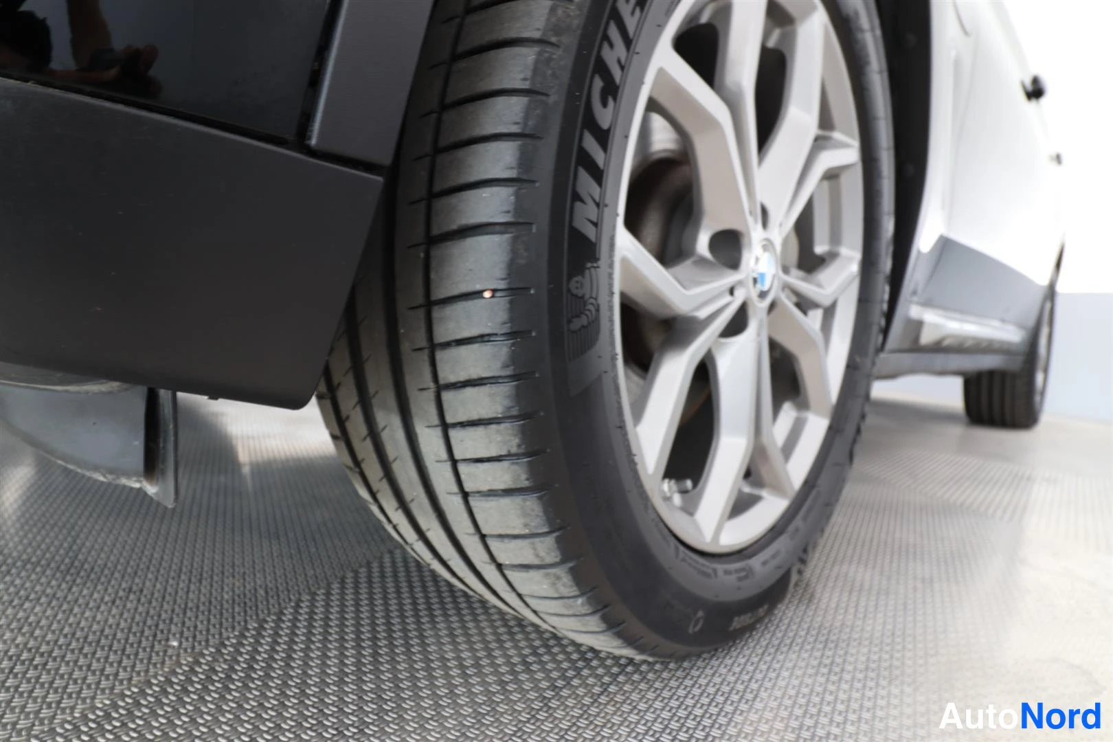 Yksityiskohta: Lähikuva auton takapyörästä, Michelin-kesärengas hopeisella alumiinivanteella.