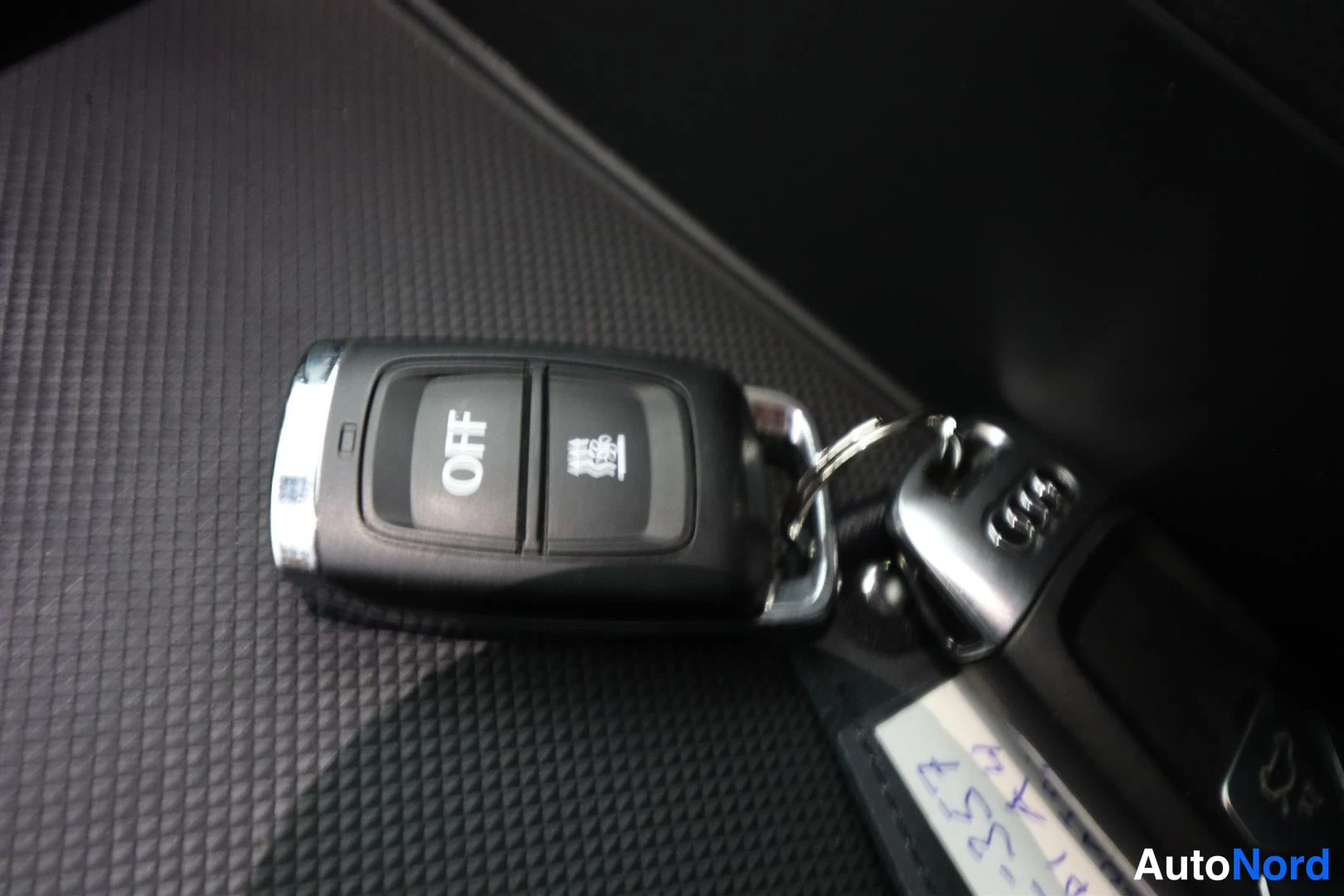 Yksityiskohta: Audi-avainnippu mustalla riippumatolla tumman sisätilan pohjalla.
