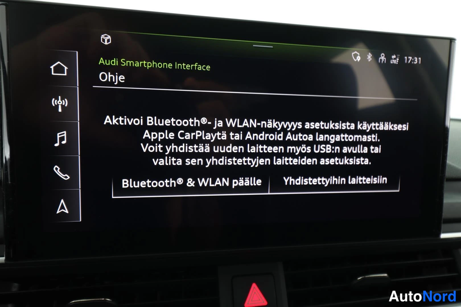 Yksityiskohta: Näytöllä Audi Smartphone Interface -ohje, jossa mainitaan Apple CarPlay ja Android Auto.