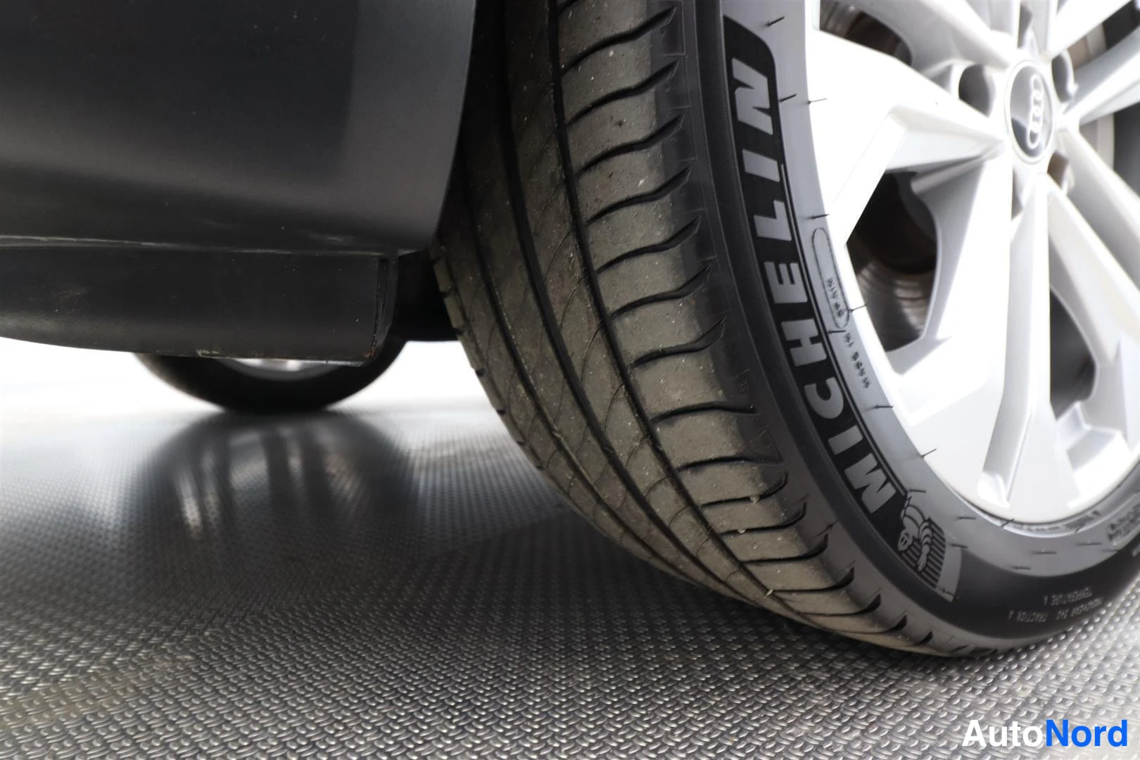 Yksityiskohta: Michelin-kesärenkaan ja hopeanharmaan vanteen lähikuva.