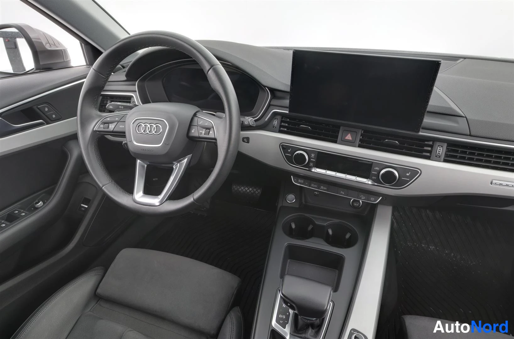 Muu: Sisätilakuva kuljettajan puolelta: Audi-ohjauspyörä, irrallinen keskinäyttö ja automaattivaihteiston vaihdevalitsin.