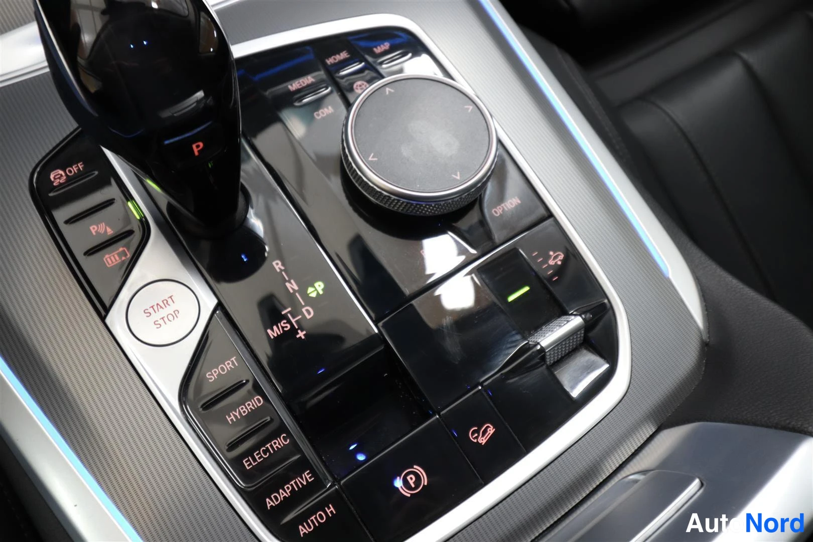 Muu: BMW:n keskinäinen konsoli: automaattivaihteen valitsin, iDrive-ohjain, start/stop-painike sekä HYBRID- ja ELECTRIC-ajotilapainikkeet.