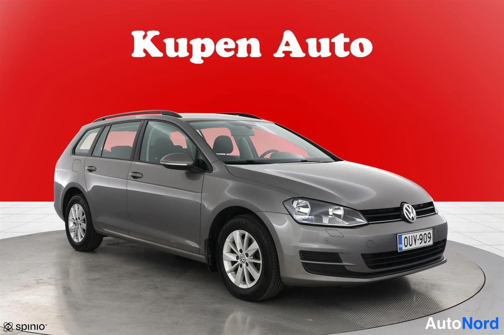 Etuviisto, nokka oikealle: Volkswagen Golf -farmari harmaana punaisella taustalla, kolme neljäsosaa edestä oikealta.