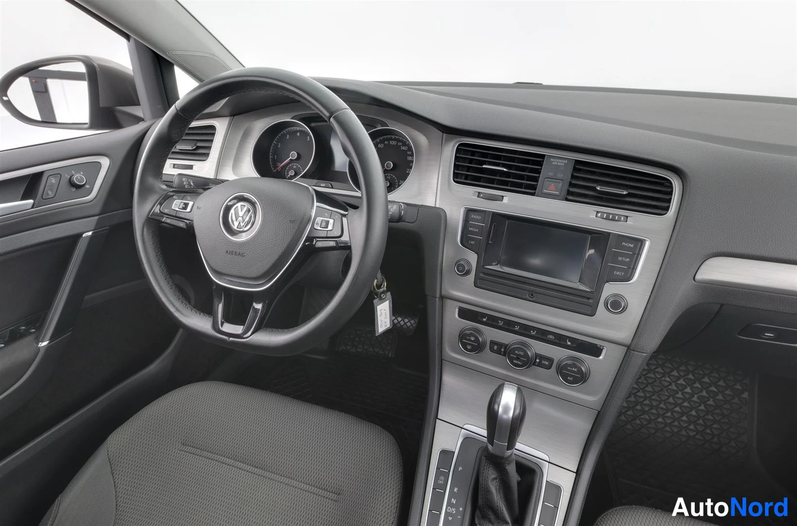 Etuistuimet: Volkswagen Golfin kuljettajan näköala: monitoimiohjauspyörä, mittaristo ja keskikonsolin radio sekä automaattivaihteen valitsin.