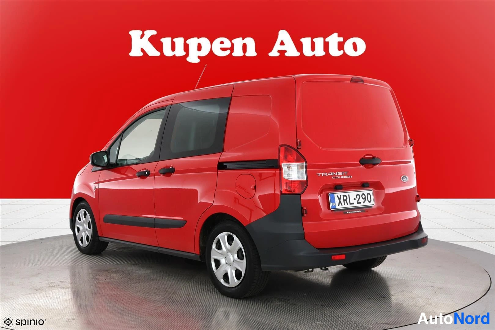 Takaviisto: Punainen Ford Transit Courier takaviistosta vasemmalta, takaluukussa Transit Courier -teksti, rekisteri.