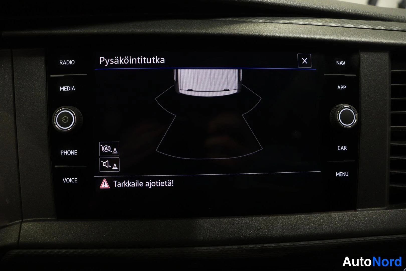 Ohjaamo: Volkswagen Transporterin keskikonsolin infotainment-näyttö, jolla näkyy Pysäköintitutka-ominaisuus.