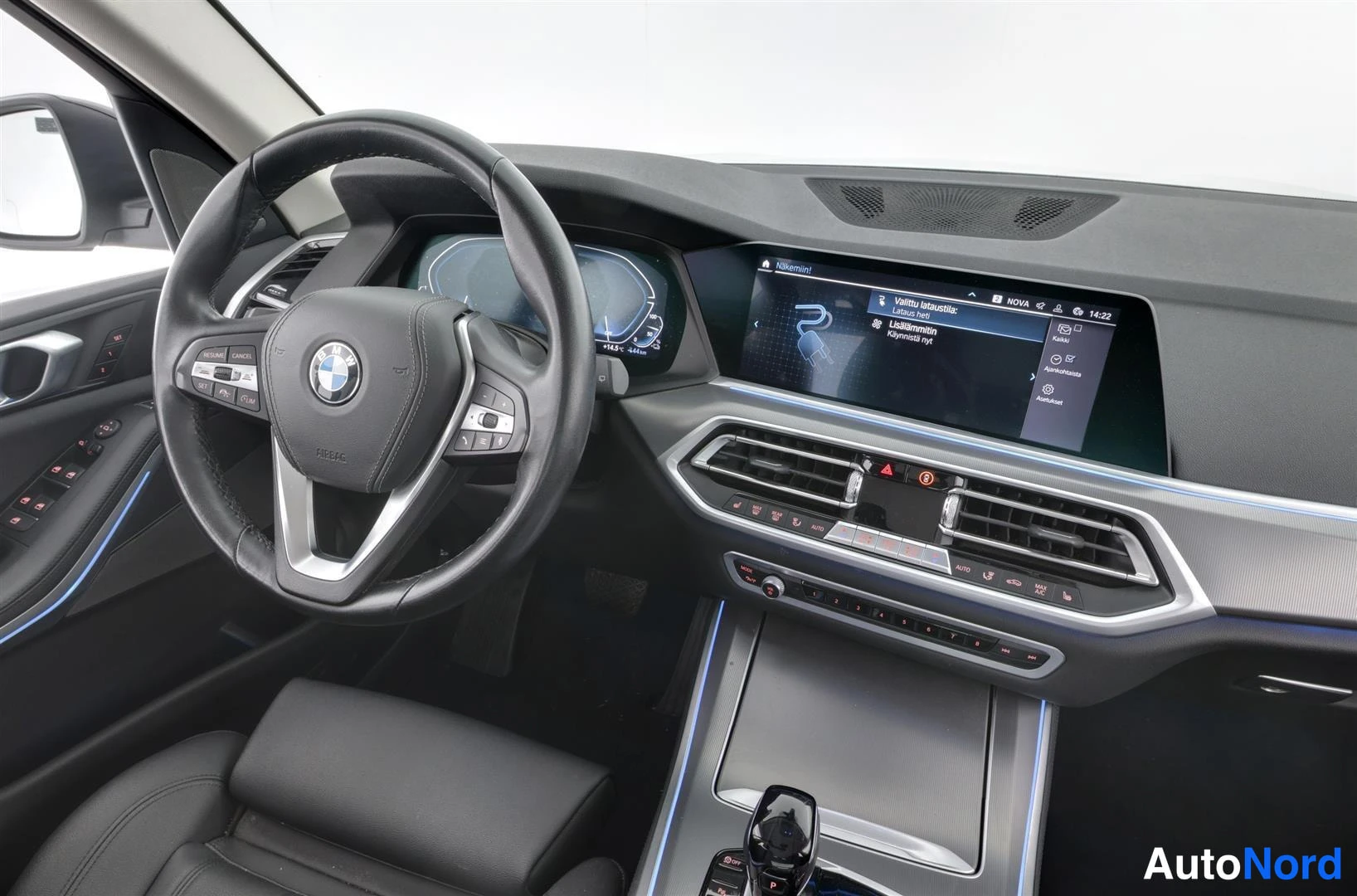 Ohjaamo: Ohjaamo BMW:n ratin ja kojelaudan näkymä, keskellä infotainment-näyttö ja tummat istuimet.