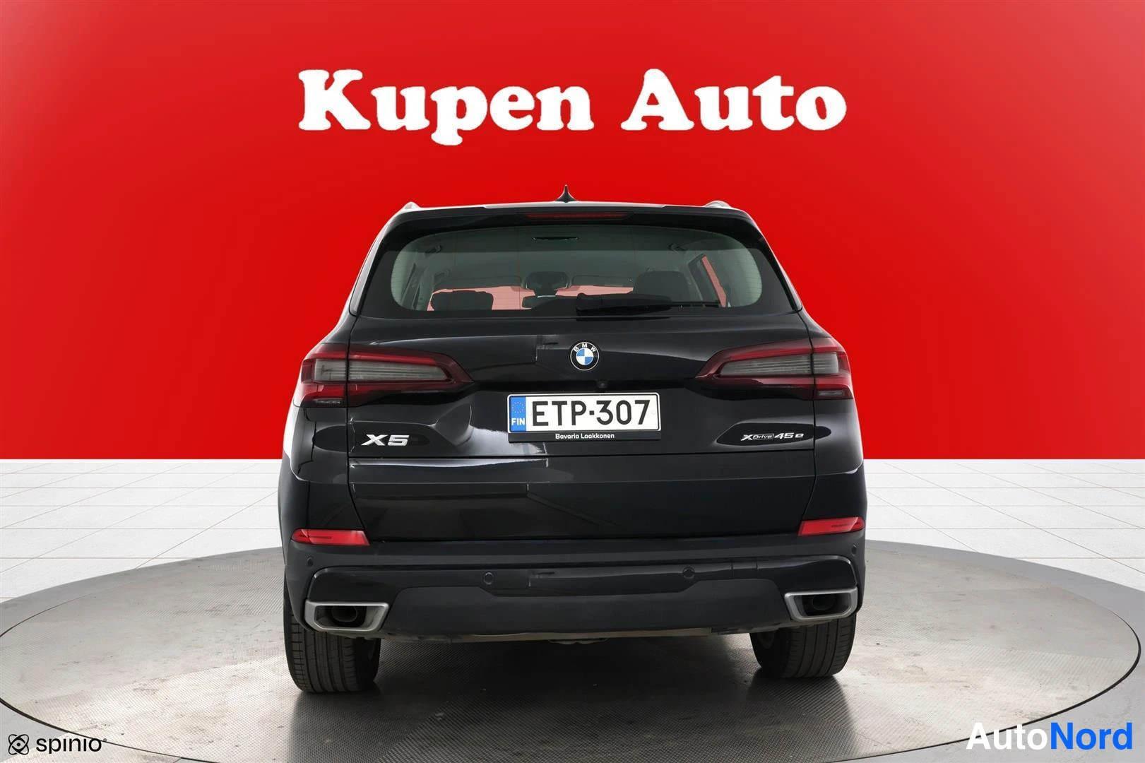 Takaa: Mustan BMW X5:n takanäky, rekisterikilpi, punainen tausta.
