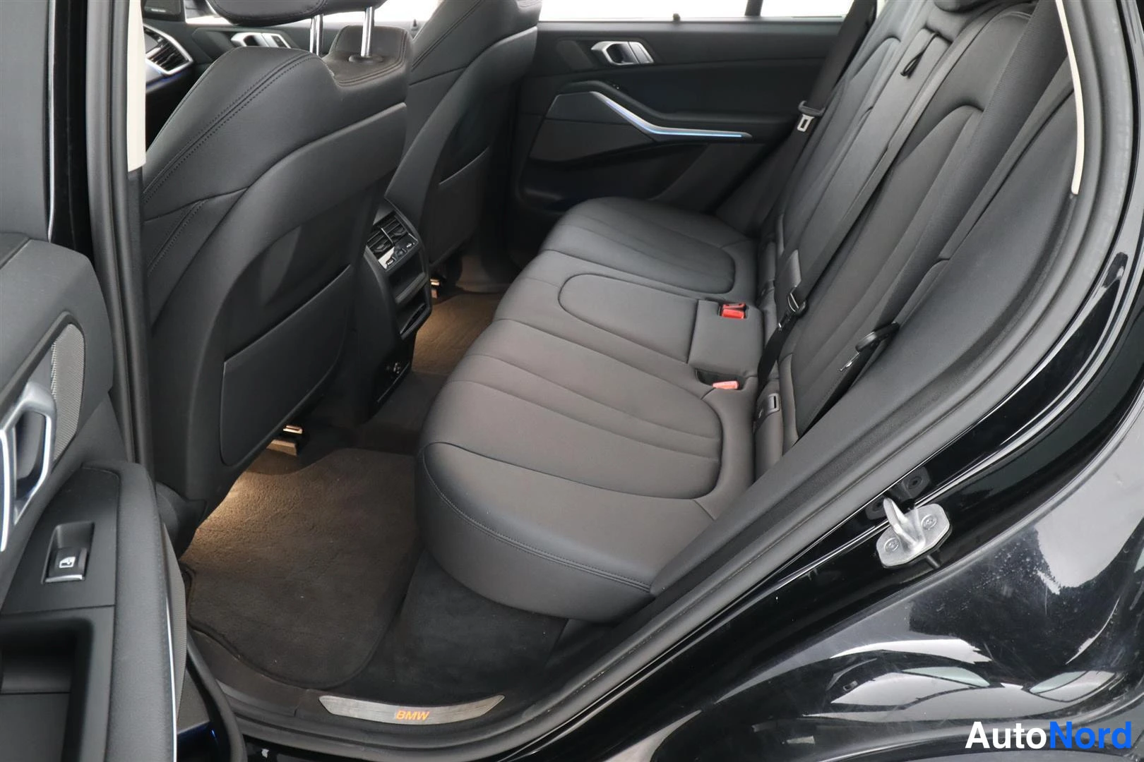 Takaistuimet: BMW X5:n takaistuinpenkki mustalla nahkasisustuksella.