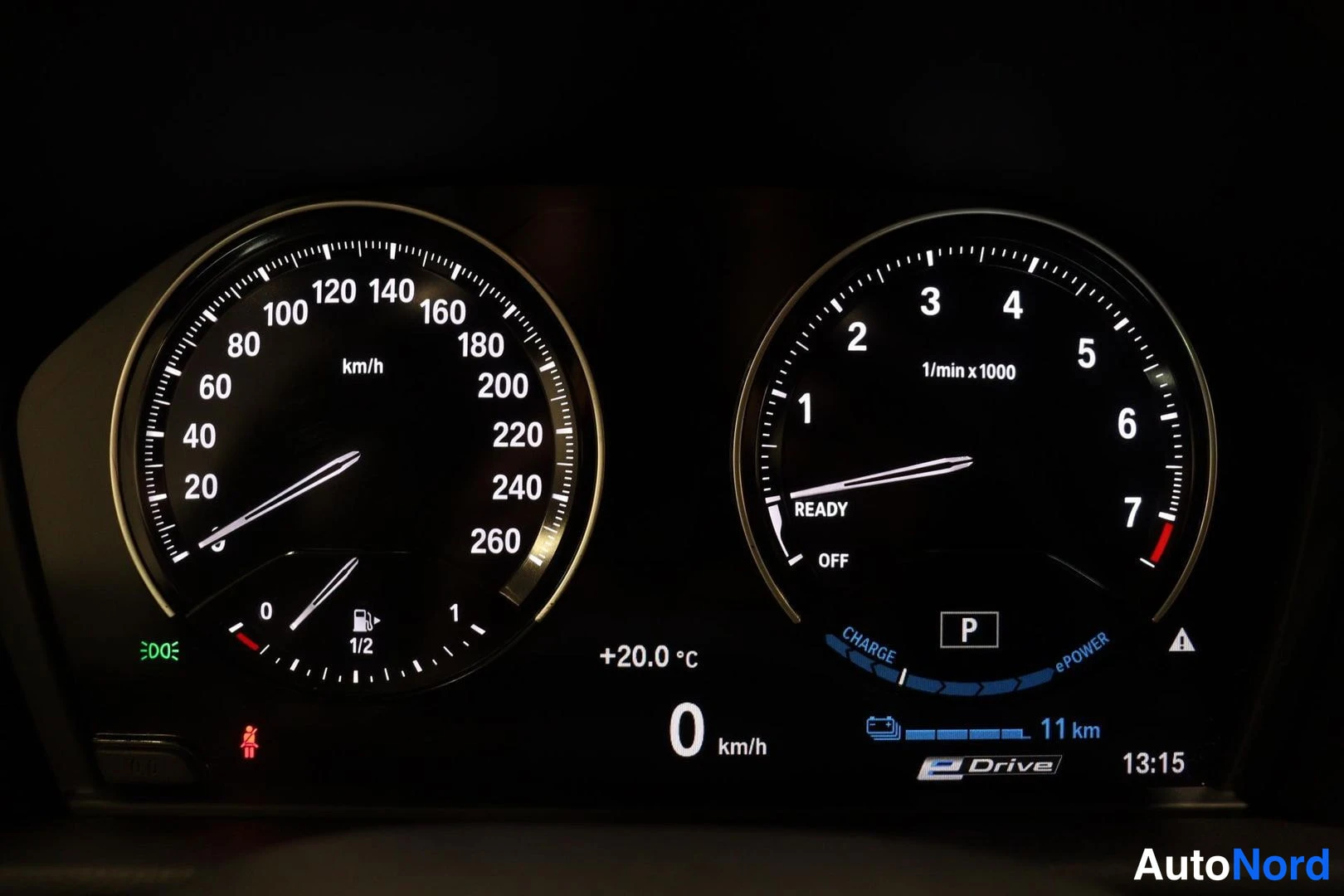 Yksityiskohta: Mittareiden lähikuva: nopeusmittari, kierroslukumittari, polttoainemittari, ulkolämpötila 20.0°C, ajoneuvon sijainti P, virtamoodi 'READY' ja E-Drive -merkki.