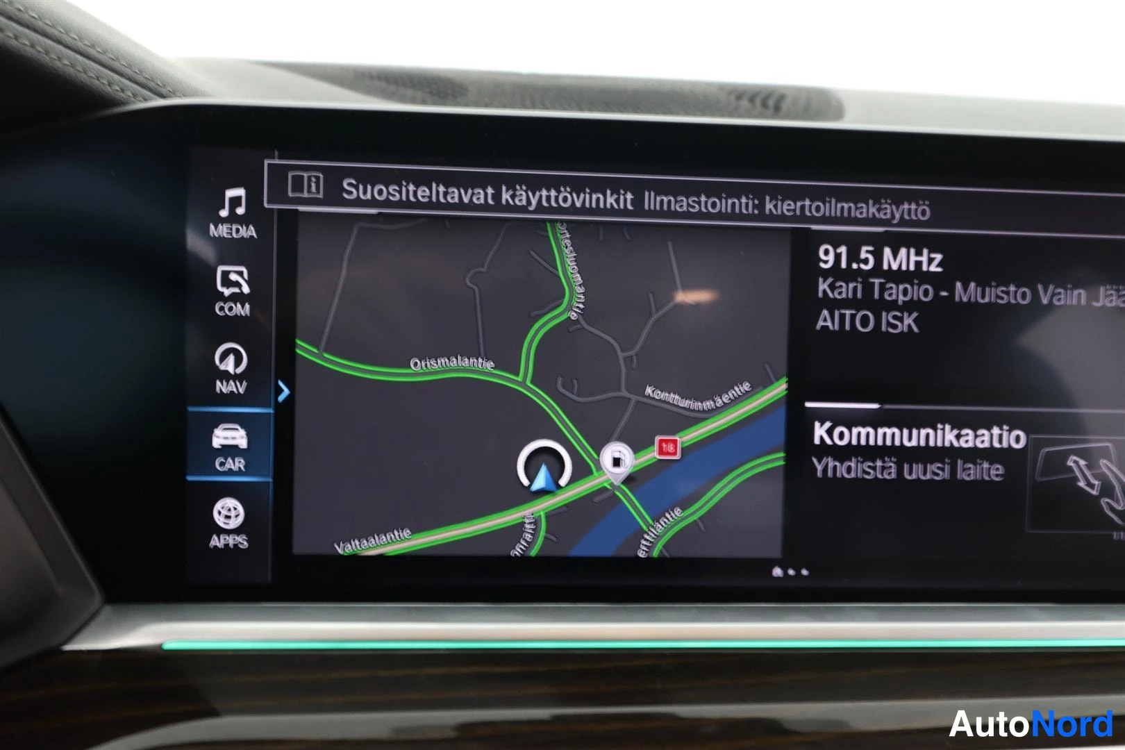 Ohjaamo: Auton infotainment-näyttö: navigointikartta, valikot MEDIA, COM, NAV, CAR, APPS, radiokanava 91.5 MHz ja viesti 'Suositeltavat käyttövinkit Ilmastointi: kiertoi