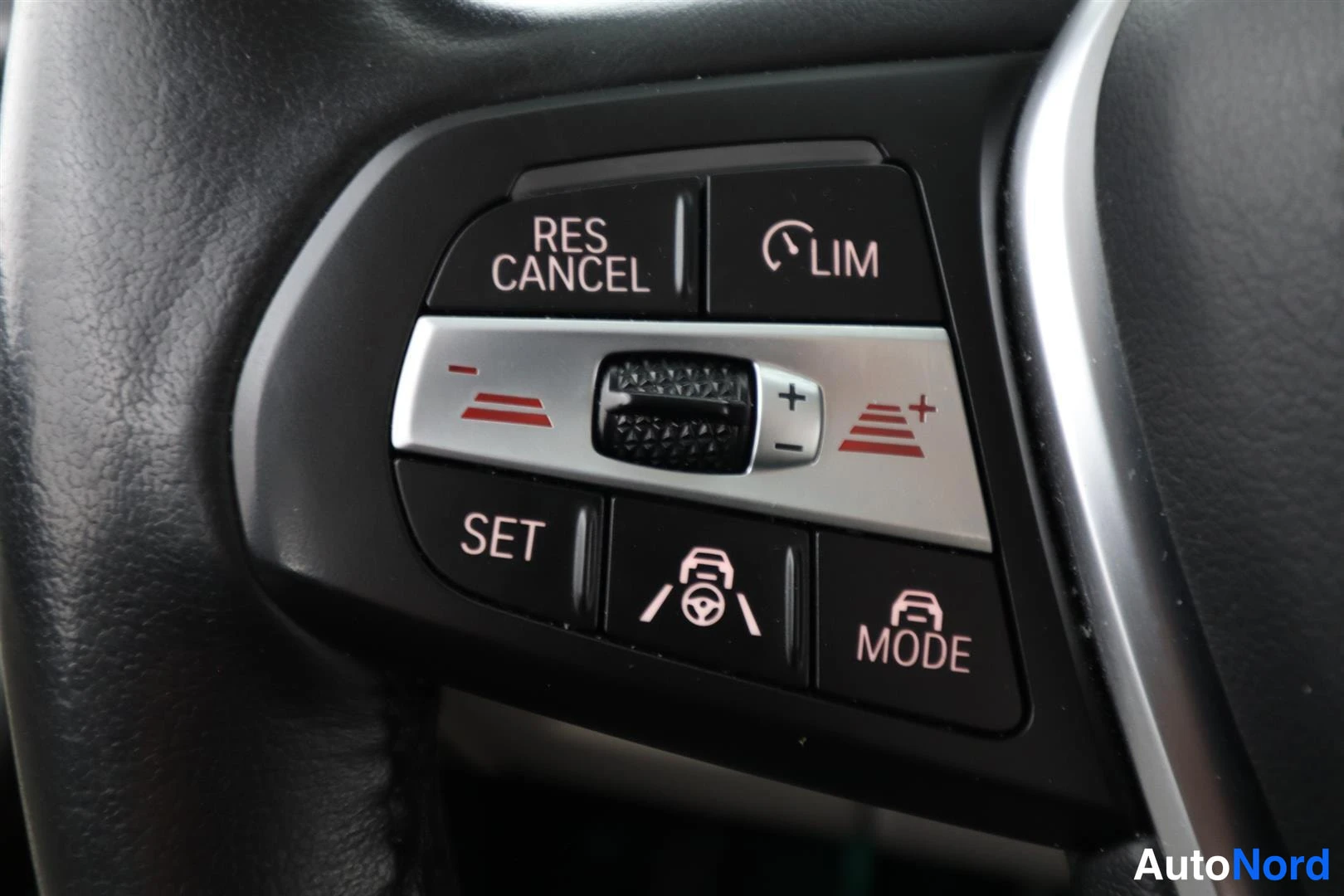 Yksityiskohta: Rattinapin cruise control - ja kuljettaja-apunäppäimet: RES CANCEL, LIM, SET, MODE ja etäisyys-/kaistamerkit.