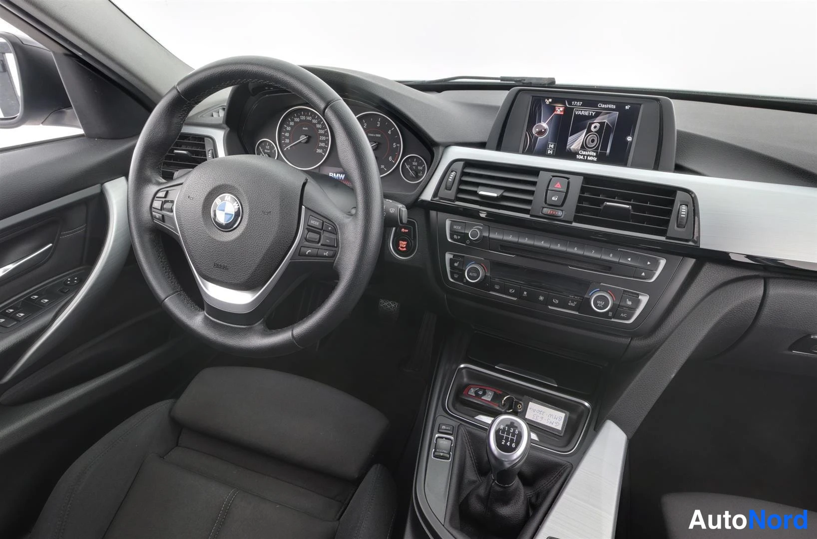 Ohjaamo: BMW:n ohjaamo kuljettajan puolelta kuvattuna: rati, mittaristo, radiojärjestelmä ja manuaalivaihdekeila.