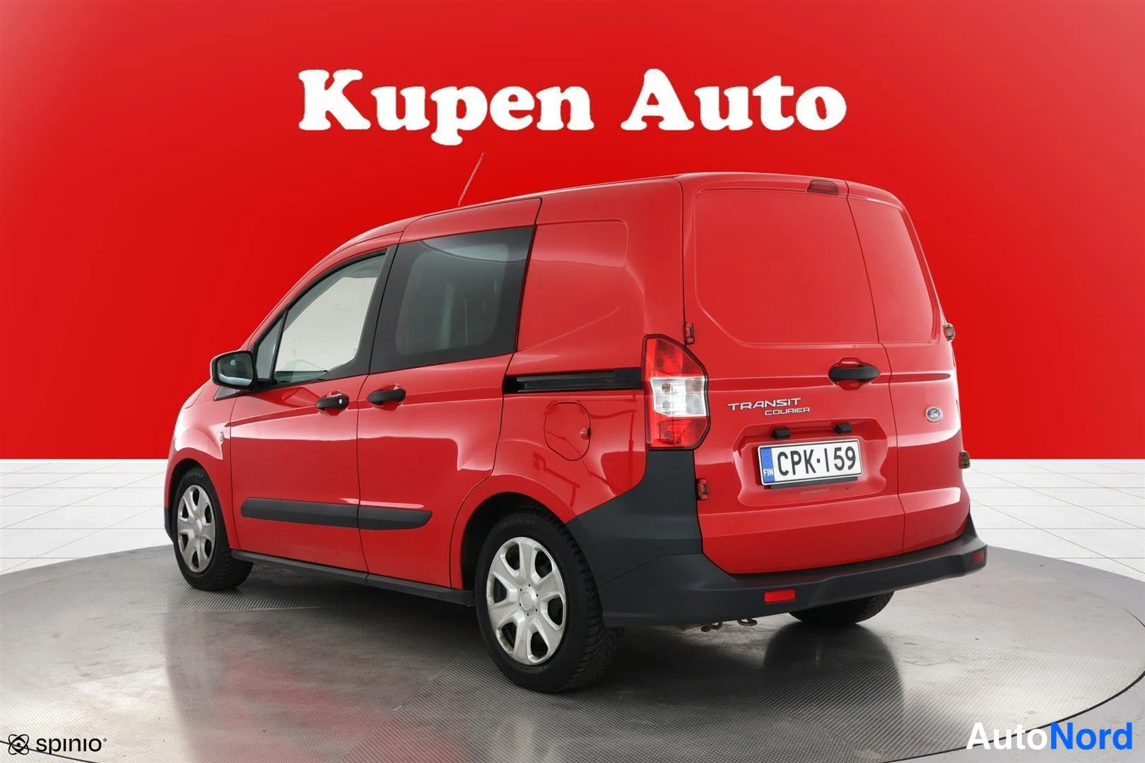 Takaviisto: Punainen Ford Transit Courier takakulmasta vasemmalta, peräosassa Transit Courier -teksti.