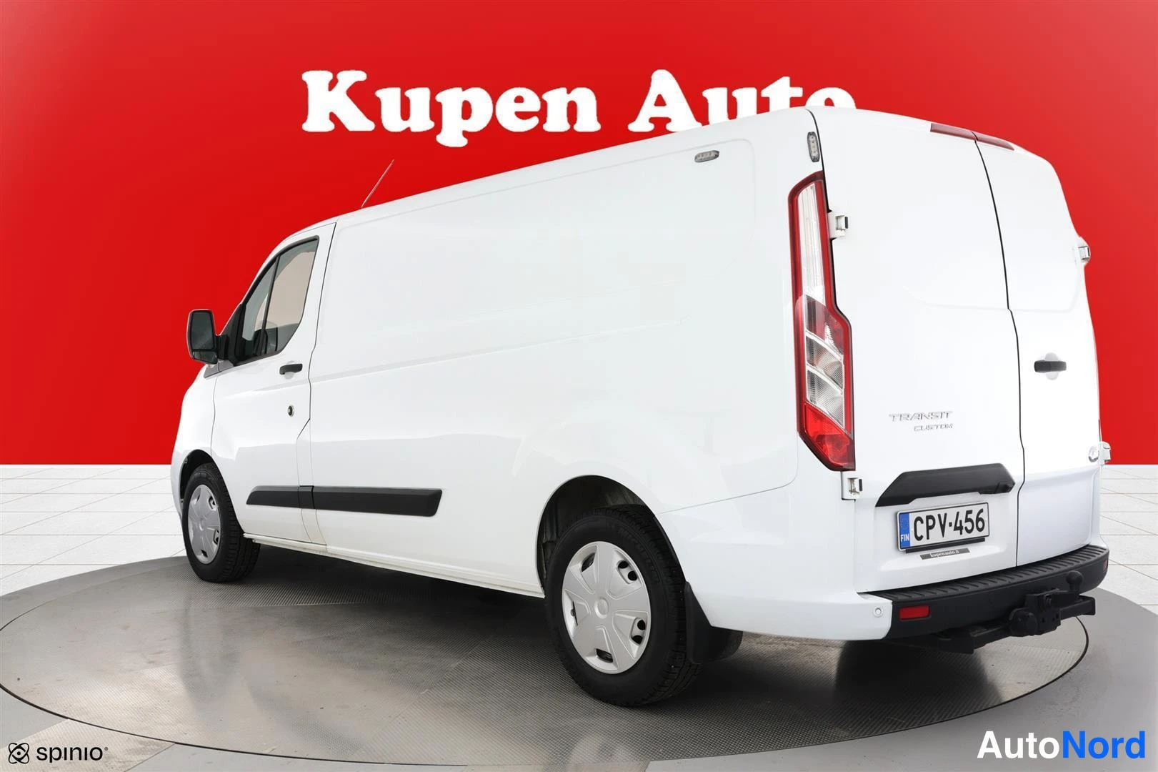 Takaviisto: Valkoisen Ford Transit Custom -pakettiauton takaosa ja vasen sivu kulmasta, takana lukittava vetokoukku
