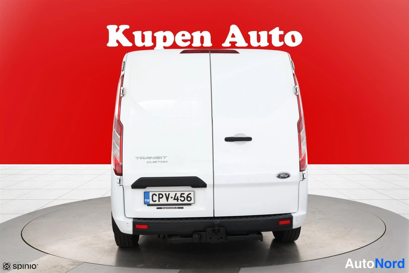 Takaa: Ford Transit Custom -pakettiauto takaa valkoisena, rekisteritunnus, punainen tausta.