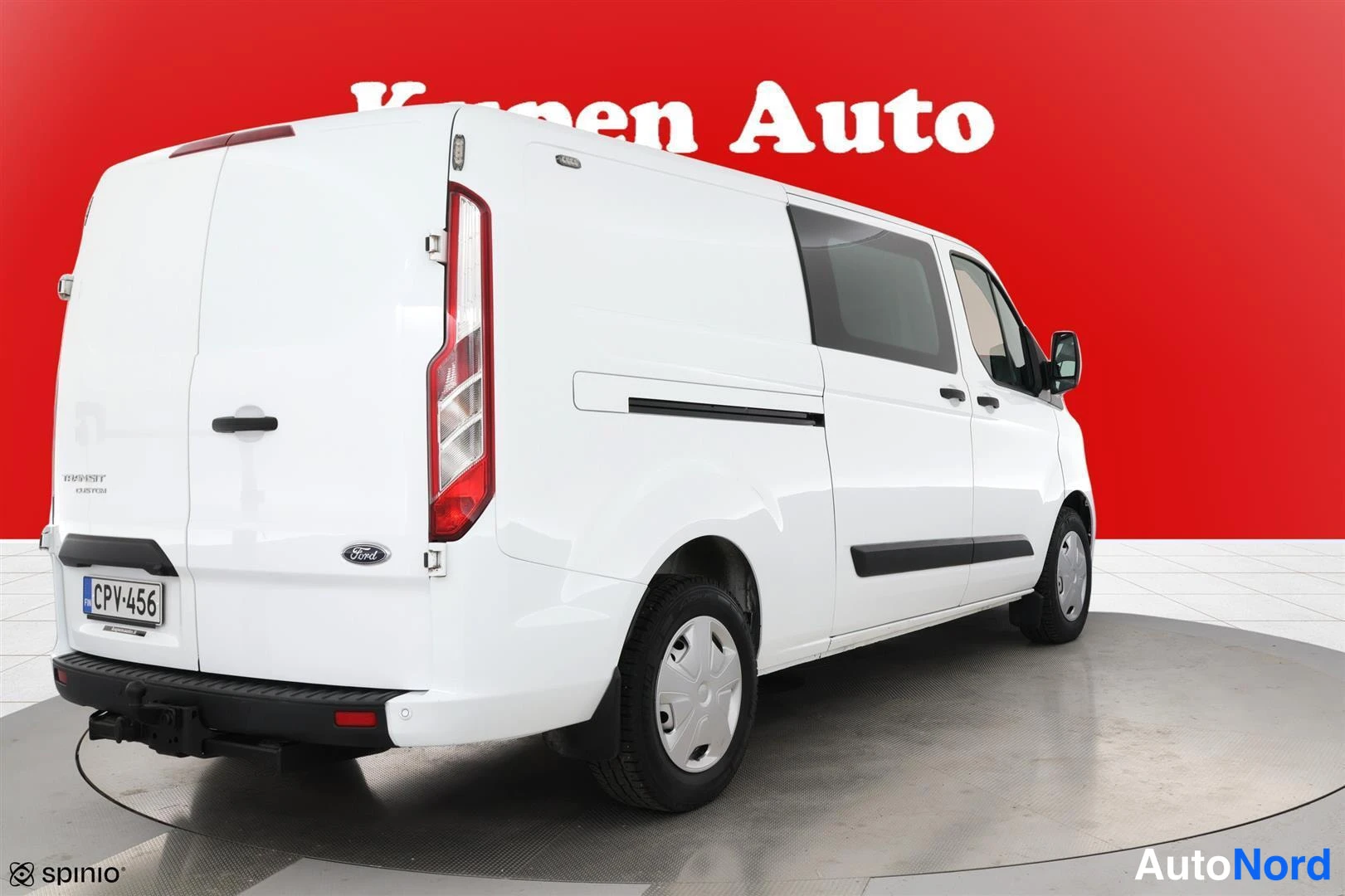 Takaviisto: Ford Transit Custom -pakettiauto takaviistosta valkoisena, sivu ja takaosa näkyvissä.