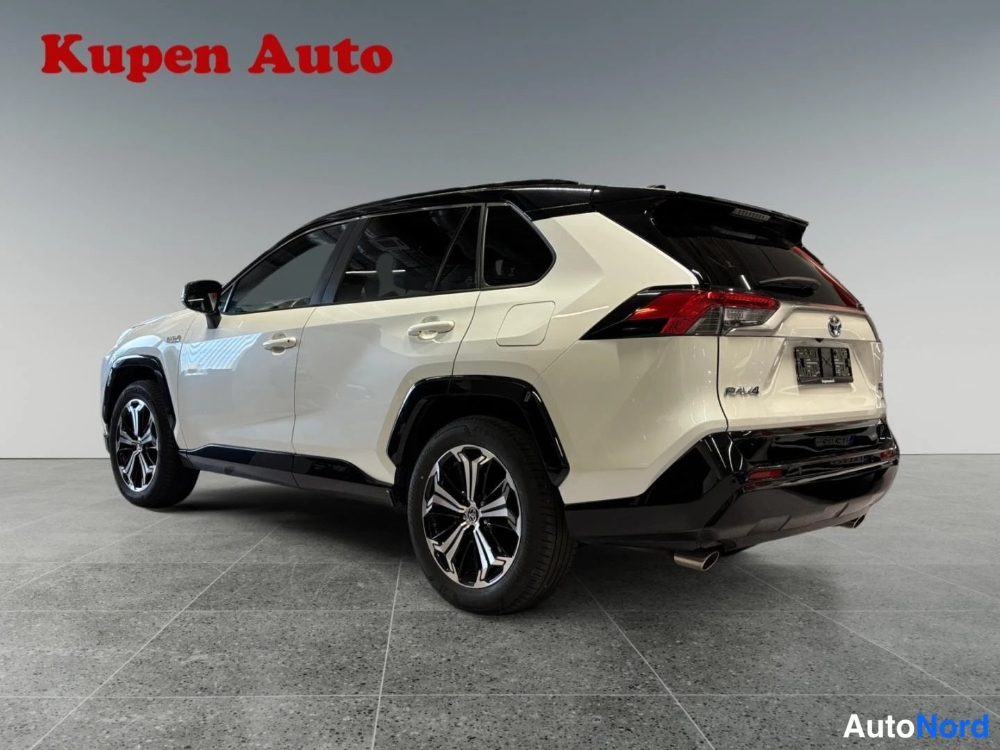 Takaviisto: Valkoinen Toyota RAV4, takakulmanäkymä oikealta, musta katto ja mustat lokasuojat, hopeavanteet.