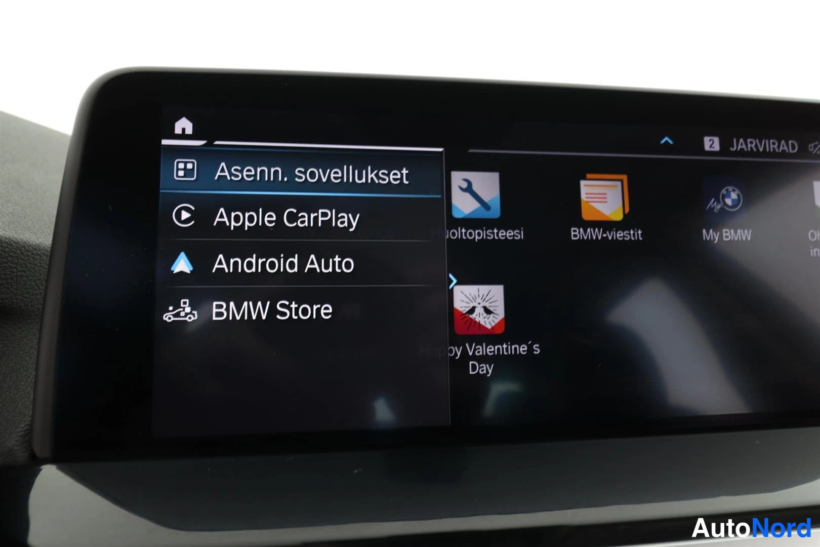 Yksityiskohta: Infotainment-näytön sovellusvalikko, jossa vaihtoehdot Apple CarPlay, Android Auto ja BMW Store.