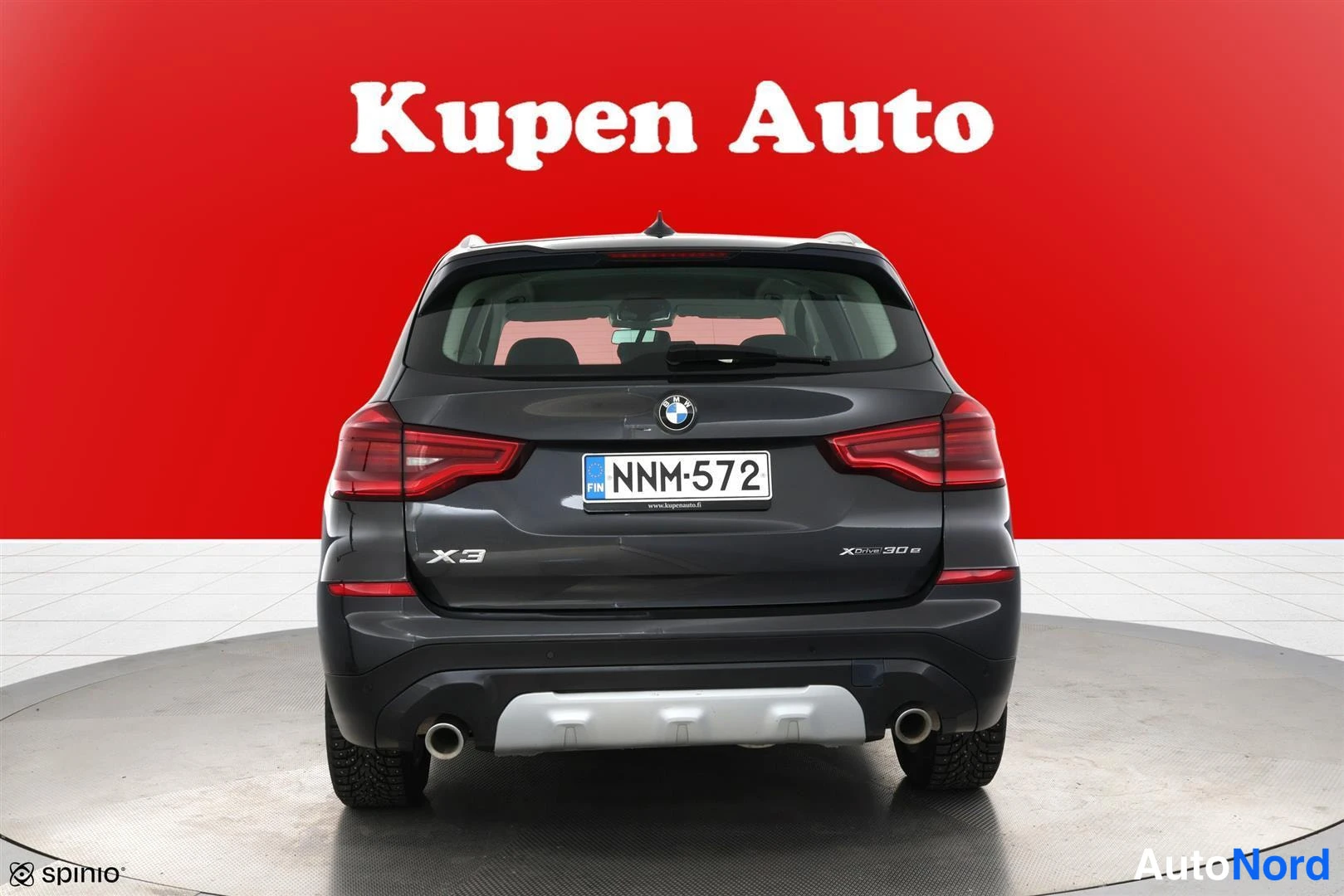 Takaa: BMW X3:n takaa otettu kuva, rekisterikilpi, tummanharmaa koristeltu punaisella taustalla.