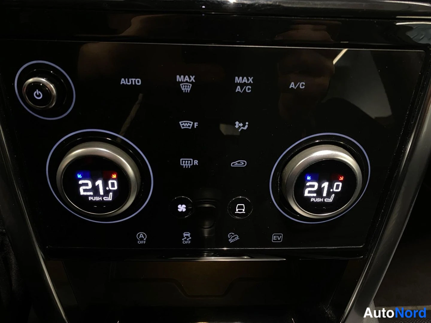 Ohjaamo: Ilmastointipaneeli, molempien nurien asetus 21.0 astetta, AUTO-, MAX-, A/C- ja A OFF-painikkeet sekä EV-merkintä.