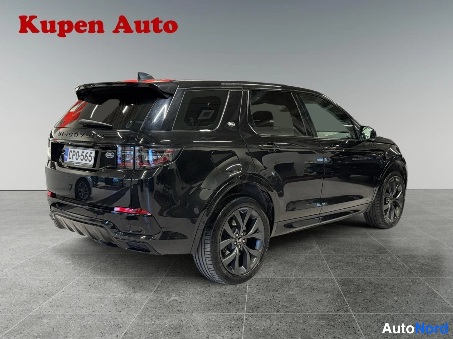 Takaviisto: Musta Land Rover Discovery Sport kulmatäkuvassa takaa oikealta, rekisteritunnus CP0-565.