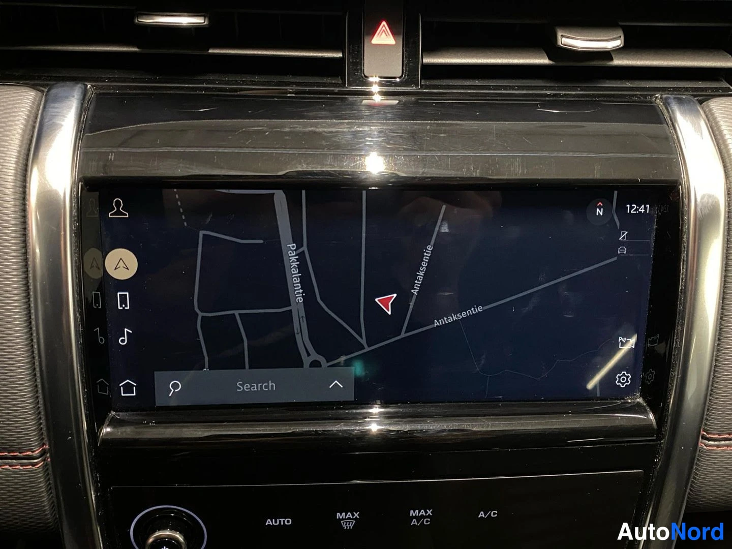 Ohjaamo: Kojelaudan infotainment-näyttö, jolla näkyy navigaatiokartta (Palkalentie, Antaksentie) ja alareunassa ilmastoinnin AUTO-, MAX- ja A/C-painikkeet.