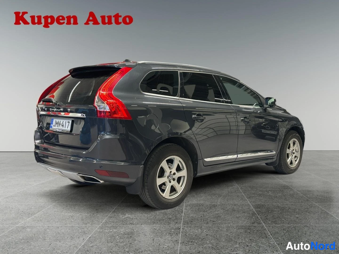 Takaviisto: Tummanharmaa Volvo XC60 takakulmakuva sisätiloissa, rekisteritunnus.