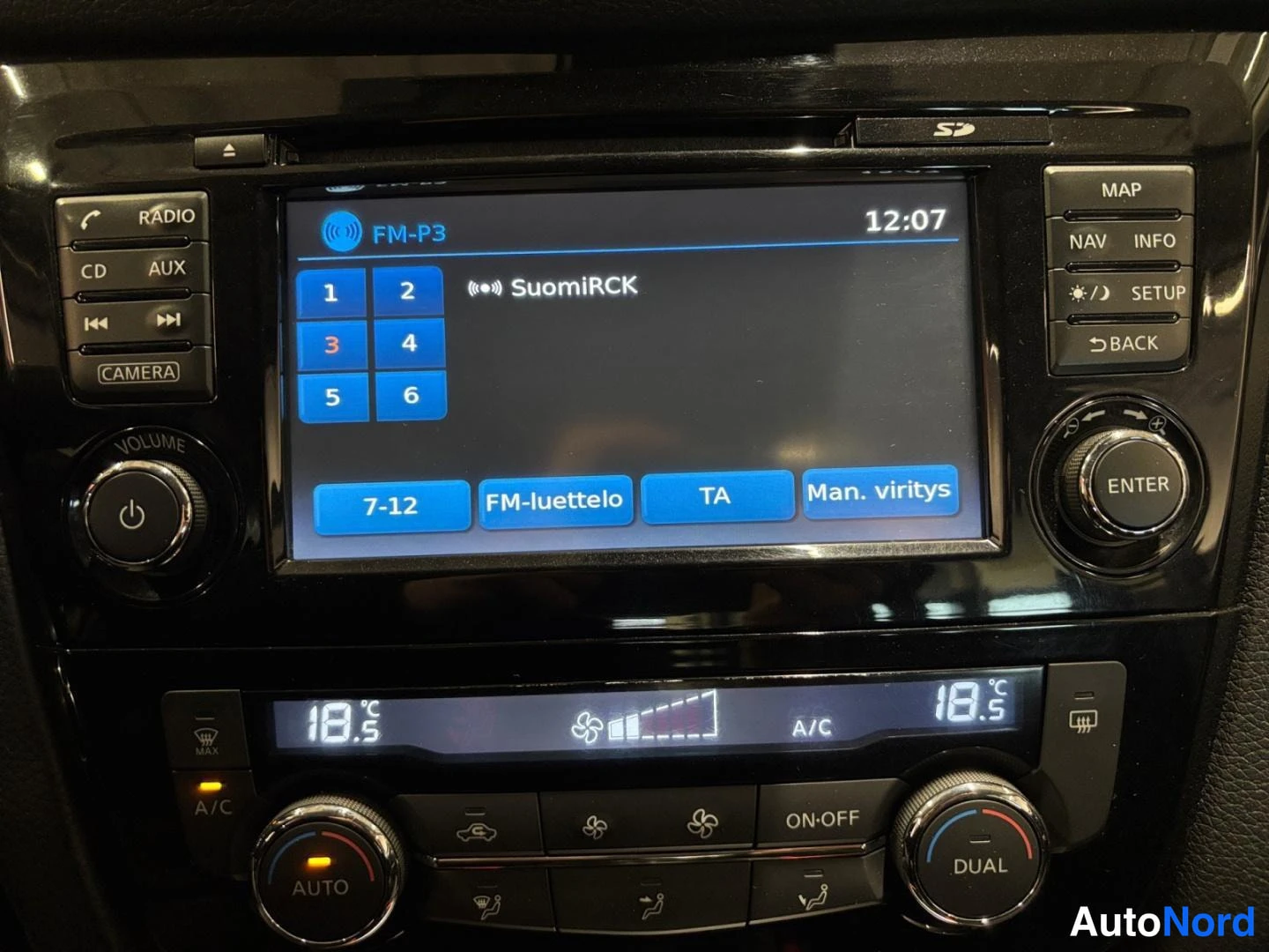 Ohjaamo: Keskihallinnan näyttö FM-radiolla (SuomiRCK), alla kaksivyöhykeilmastointipaneeli.