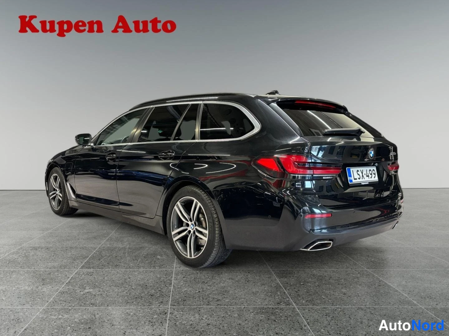 Takaviisto: Musta BMW -farmari takakulmasta, rekisteritunnus, Kupen Auto -logo kuvassa.