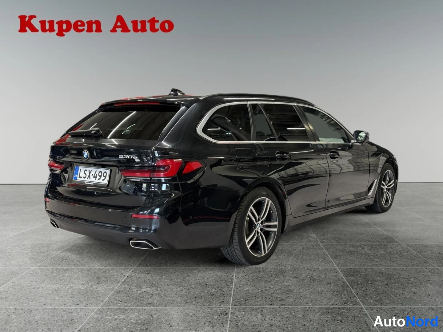 Takaviisto: Musta BMW 530e -farmari takakulmasta, 530e-merkintä takaluukussa, rekisteritunnus.