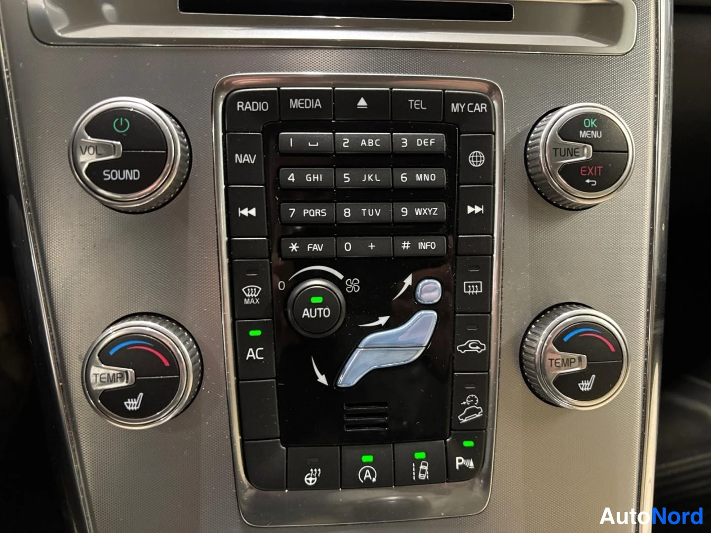 Yksityiskohta: Auton kojelaudan keskikonsolin painikkeet ja säädöt: RADIO, MEDIA, TEL, MY CAR, NAV, AC, AUTO ja TEMP-SOUND-TUNE-säätimet.