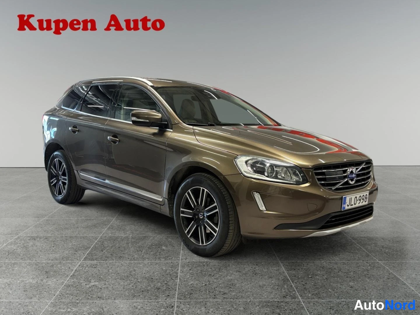 Etuviisto, nokka oikealle: Ruskea Volvo XC60 kulmauskuvassa edessä ja sivulla oikealta, rekisteritunnus JL0-998.