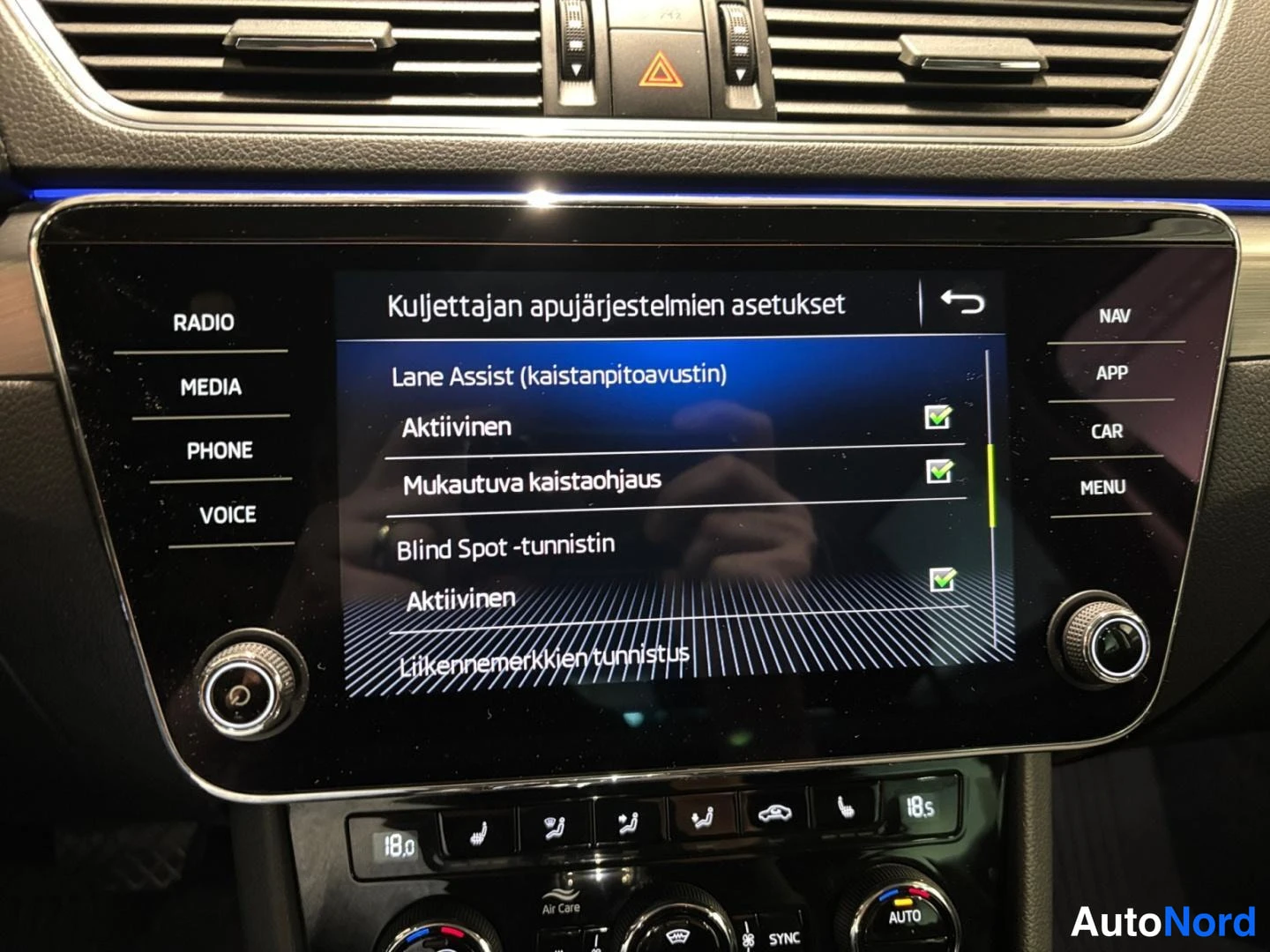 Ohjaamo: Infotainment-näytöllä Kuljettajan apujärjestelmien asetukset: Lane Assist ja Blind Spot -tunnistin aktiivisena.