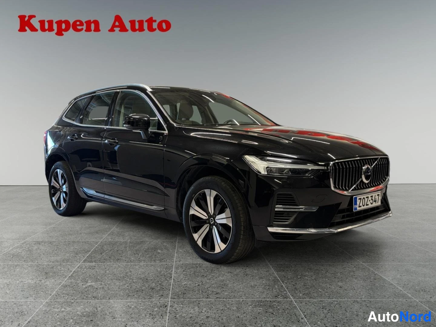 Etuviisto, nokka oikealle: Musta Volvo XC60 etuviistosta oikealta, rekisteritunnus.