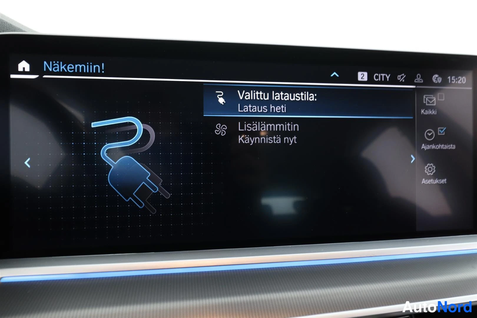 Yksityiskohta: Auton infotainment-näyttö latausvalikossa: 'Valittu lataustila: Lataus heti' ja 'Lisälämmitin Käynnistä nyt'.
