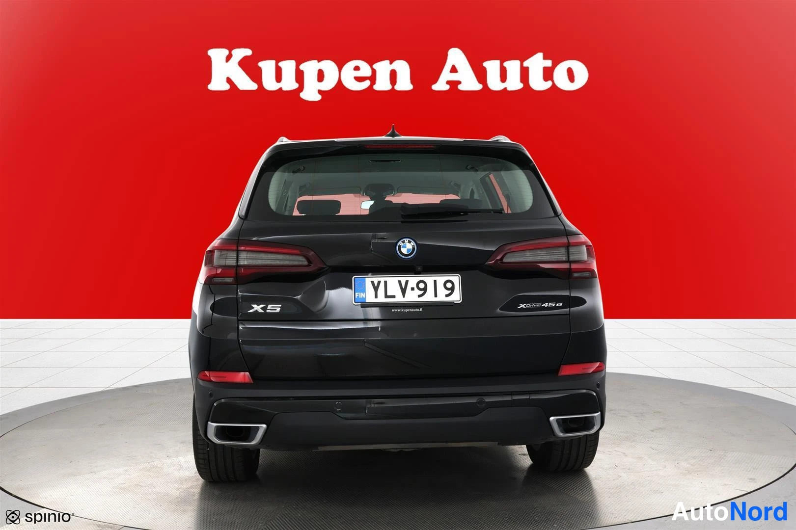 Takaa: Musta BMW X5 takaa kuvattuna, rekisteritunnus, punainen tausta.