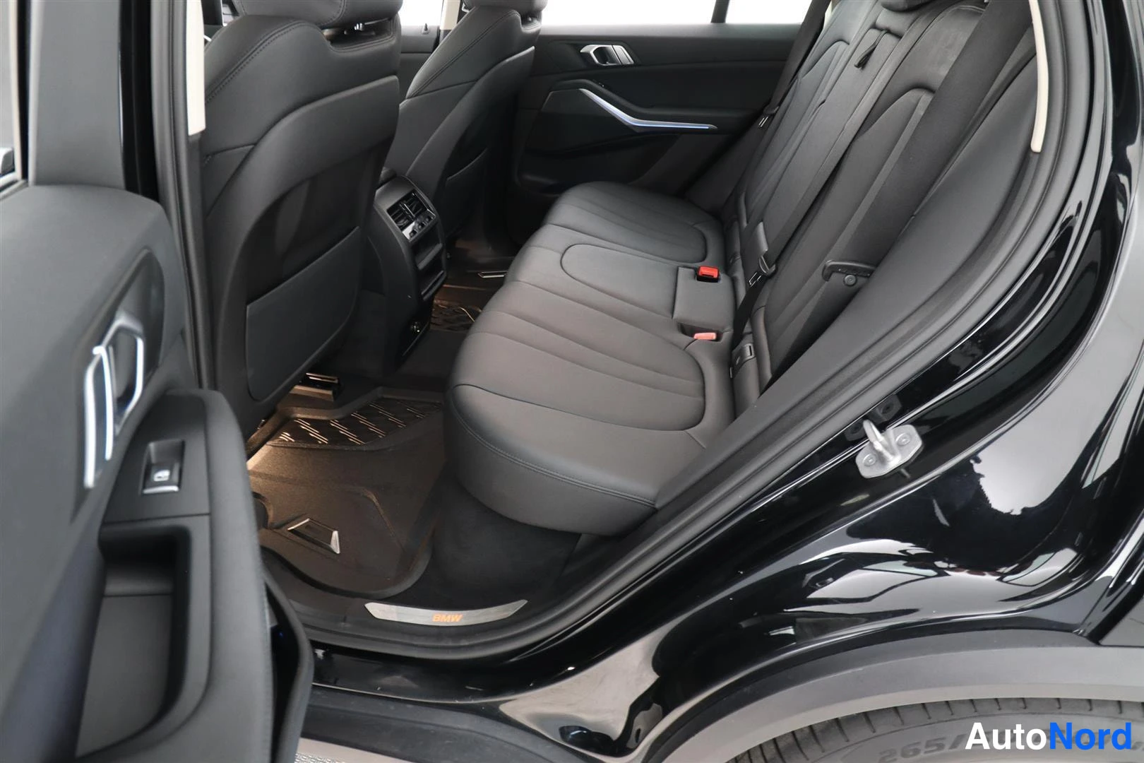 Takaistuimet: BMW X5:n takaistuin, mustat penkit ja takana olevat ovet auki.